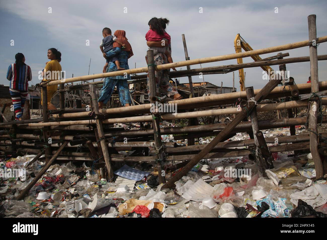 23 de febrero de 2022, Yakarta, Región Especial de la Capital de Yakarta, Indonesia: Cientos de casas ubicadas en zonas densamente pobladas en la zona de Kalibaru, Cilincing, Yakarta del Norte, Indonesia, están rodeadas de montones de basura. La pila de basura está dominada por los residuos domésticos, la mayoría de los cuales son residuos plásticos, que cubren la superficie del agua de mar y parecen un mar de basura y contaminan el medio ambiente en la zona. Esto se ve exacerbado por el número de residentes que todavía tiran basura alrededor del lugar. (Imagen de crédito: © Kuncoro Widyo Rumpoko/Pacific Press via ZUMA Press Wire) Foto de stock