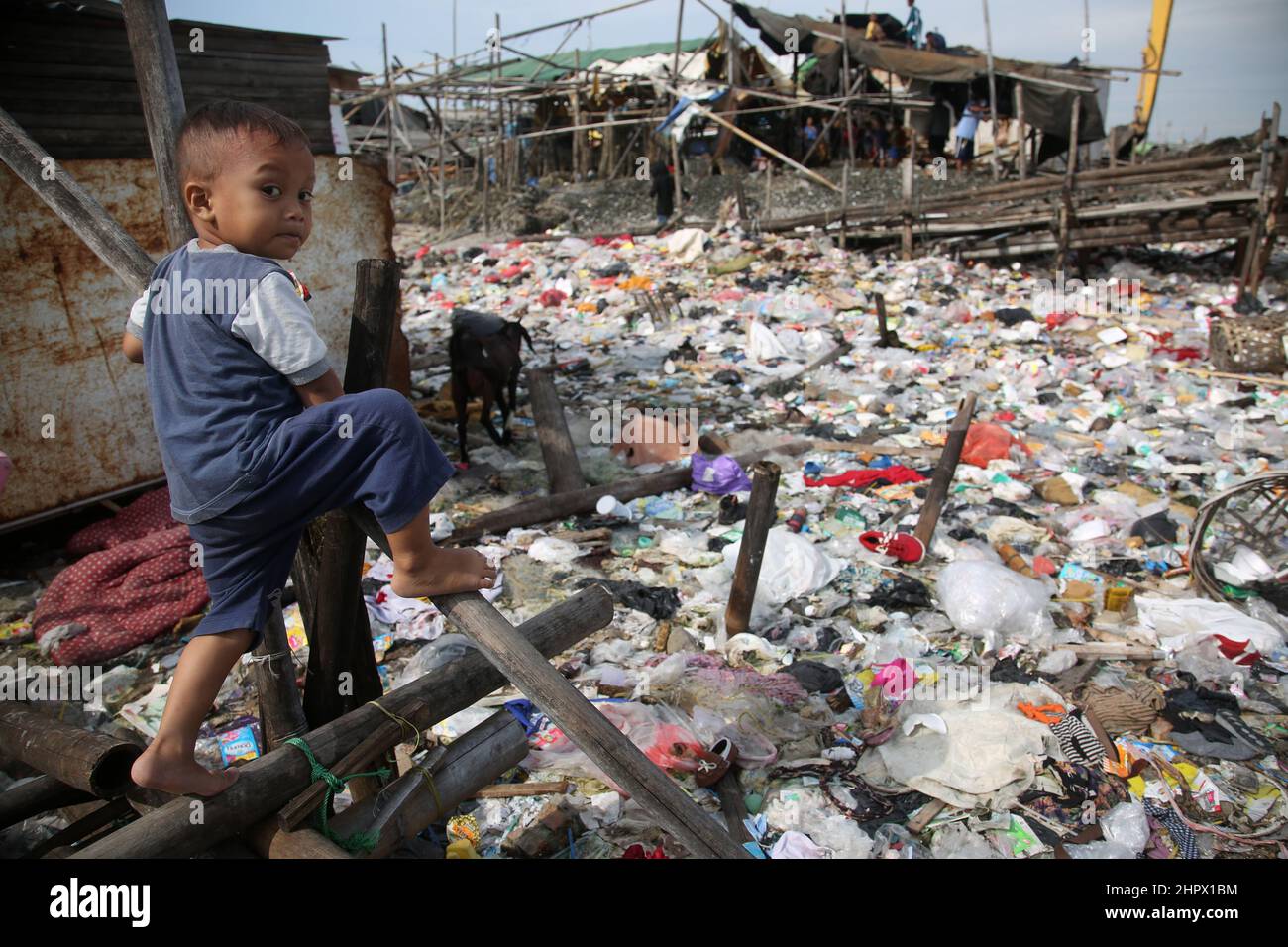 23 de febrero de 2022, Yakarta, Región Especial de la Capital de Yakarta, Indonesia: Cientos de casas ubicadas en zonas densamente pobladas en la zona de Kalibaru, Cilincing, Yakarta del Norte, Indonesia, están rodeadas de montones de basura. La pila de basura está dominada por los residuos domésticos, la mayoría de los cuales son residuos plásticos, que cubren la superficie del agua de mar y parecen un mar de basura y contaminan el medio ambiente en la zona. Esto se ve exacerbado por el número de residentes que todavía tiran basura alrededor del lugar. (Imagen de crédito: © Kuncoro Widyo Rumpoko/Pacific Press via ZUMA Press Wire) Foto de stock