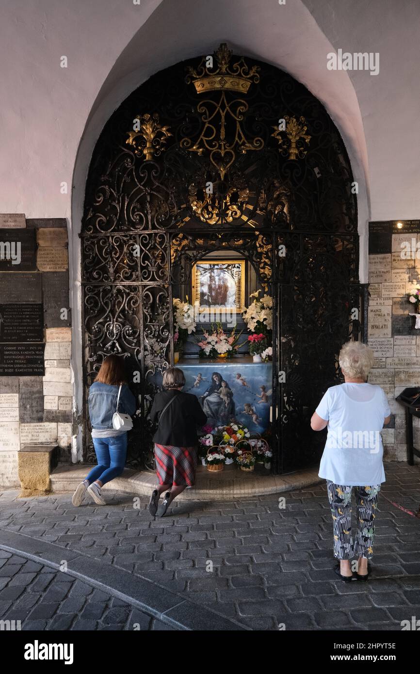 Fieles en oración en la capilla de Nuestra Señora de la Kamenita vrata (Puerta de Piedra) en Zagreb, Croacia Foto de stock