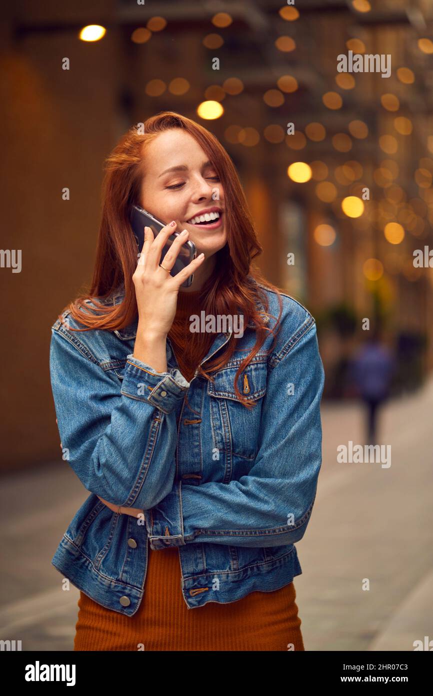 Vlogger mujer viajando a través de la ciudad haciendo llamada telefónica en el teléfono móvil en la calle Foto de stock