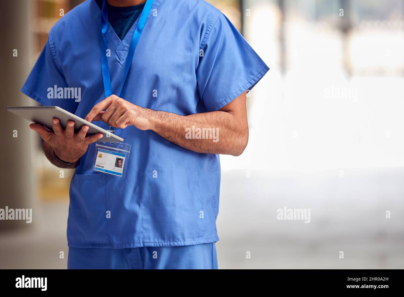 Primer plano de trabajador médico masculino en Scrubs con tableta digital en el hospital Foto de stock