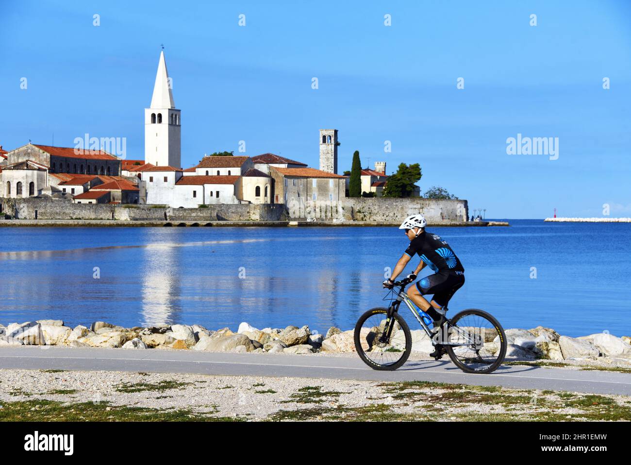 Casco antiguo en el mar Adriático con ciclista en primer plano, Croacia, Istria, Porec Foto de stock