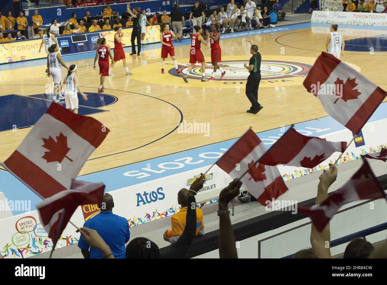 Los aficionados canadienses ondean banderas mientras celebran un punto  durante la victoria de Canadá 78-53 sobre Argentina durante el baloncesto  femenino en los partidos de Pan Am en Toronto el viernes, 17