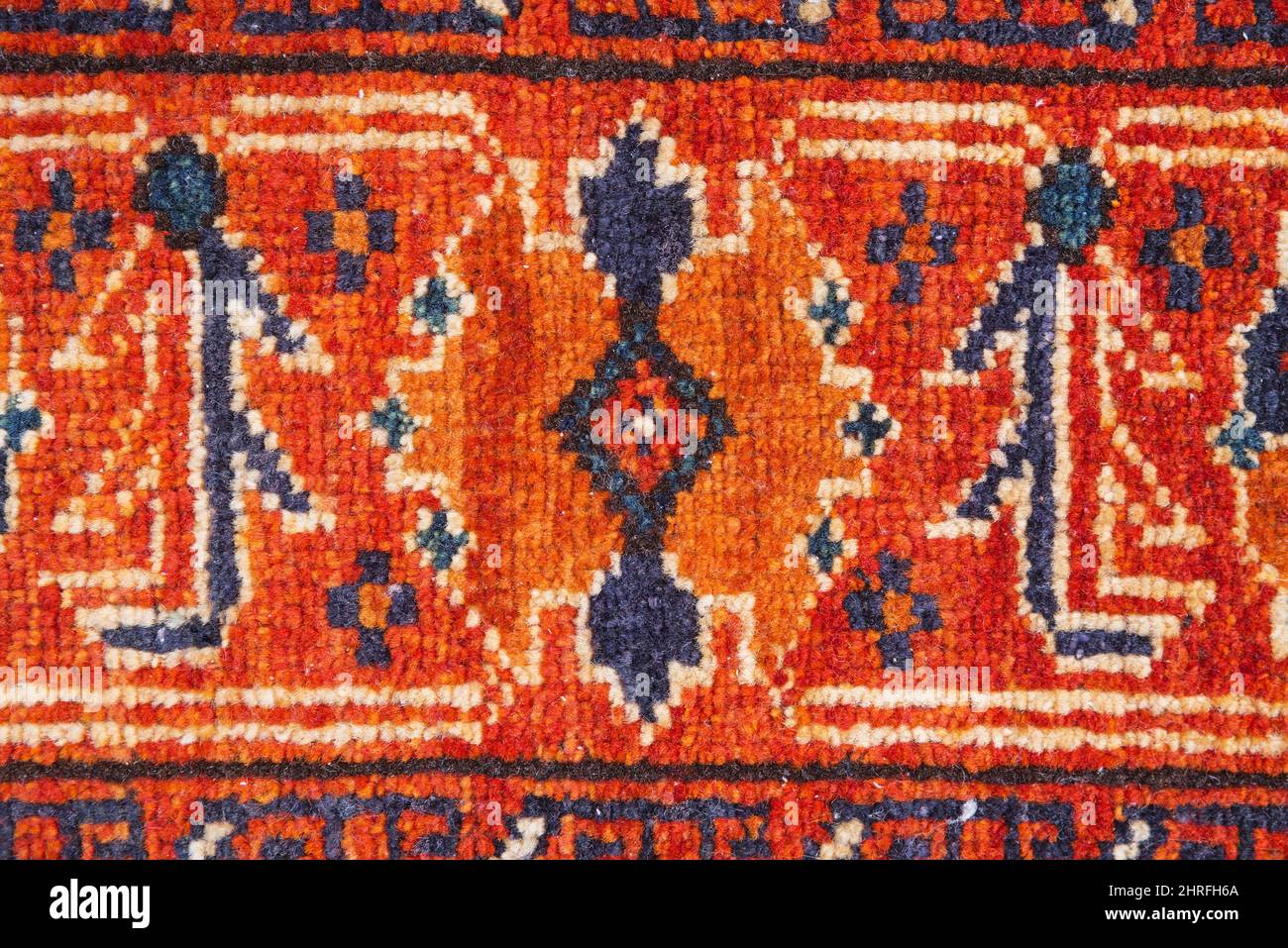 Imagen de fondo con detalle de alfombra oriental roja naranja y azul Foto de stock