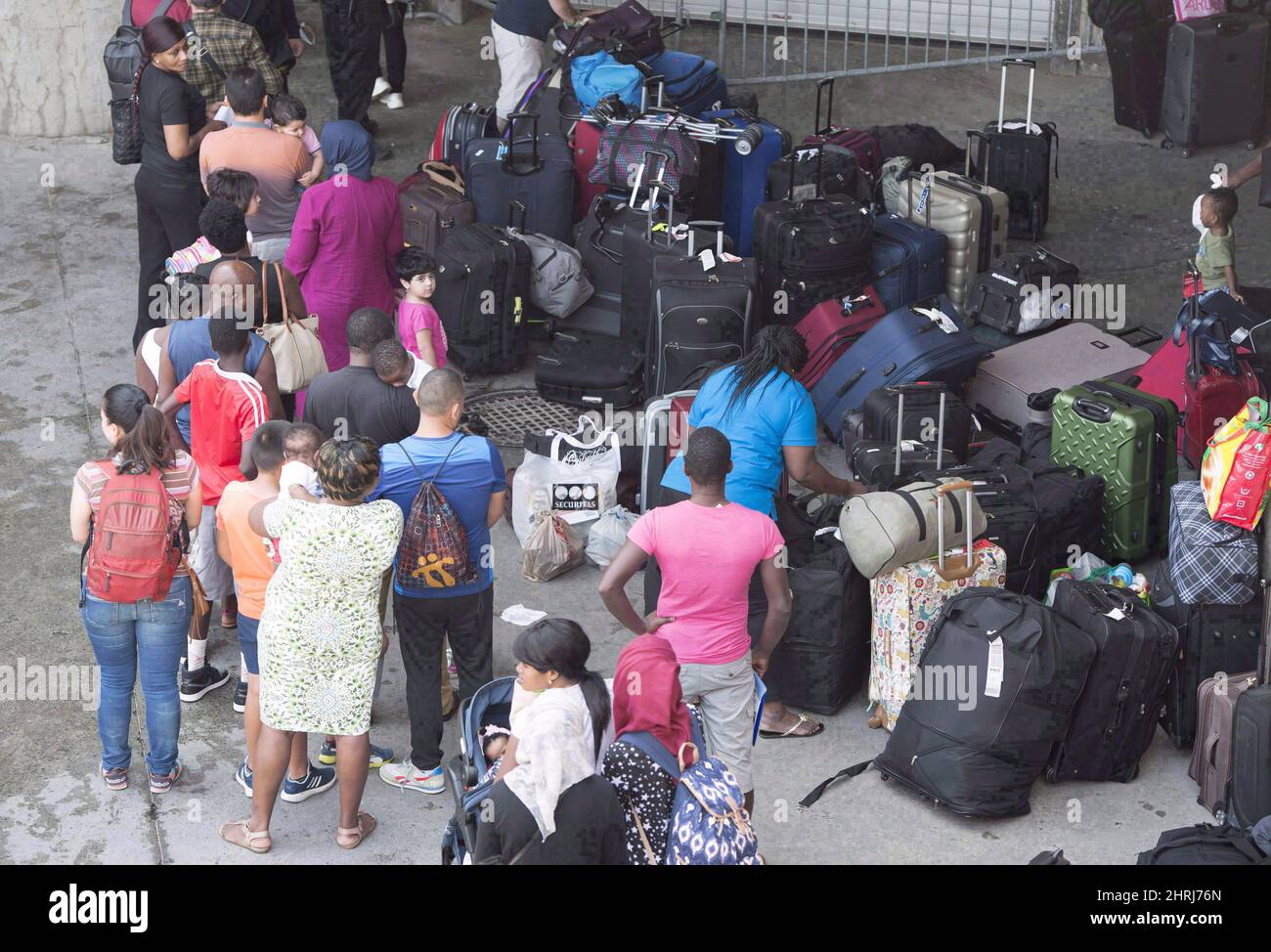 Solicitantes de asilo se alinean para entrar en el Estadio Olímpico Viernes, 4 de agosto de 2017 cerca de Montreal, Quebec. Un programa que cubre los costos de salud para los refugiados y solicitantes de asilo en Canadá está recibiendo un aumento de $283 millones en los próximos dos años, gracias a una infusión de efectivo en el sistema de inmigración de Canadá en el Presupuesto 2019. LA PRENSA CANADIENSE/Paul Chiasson Foto de stock