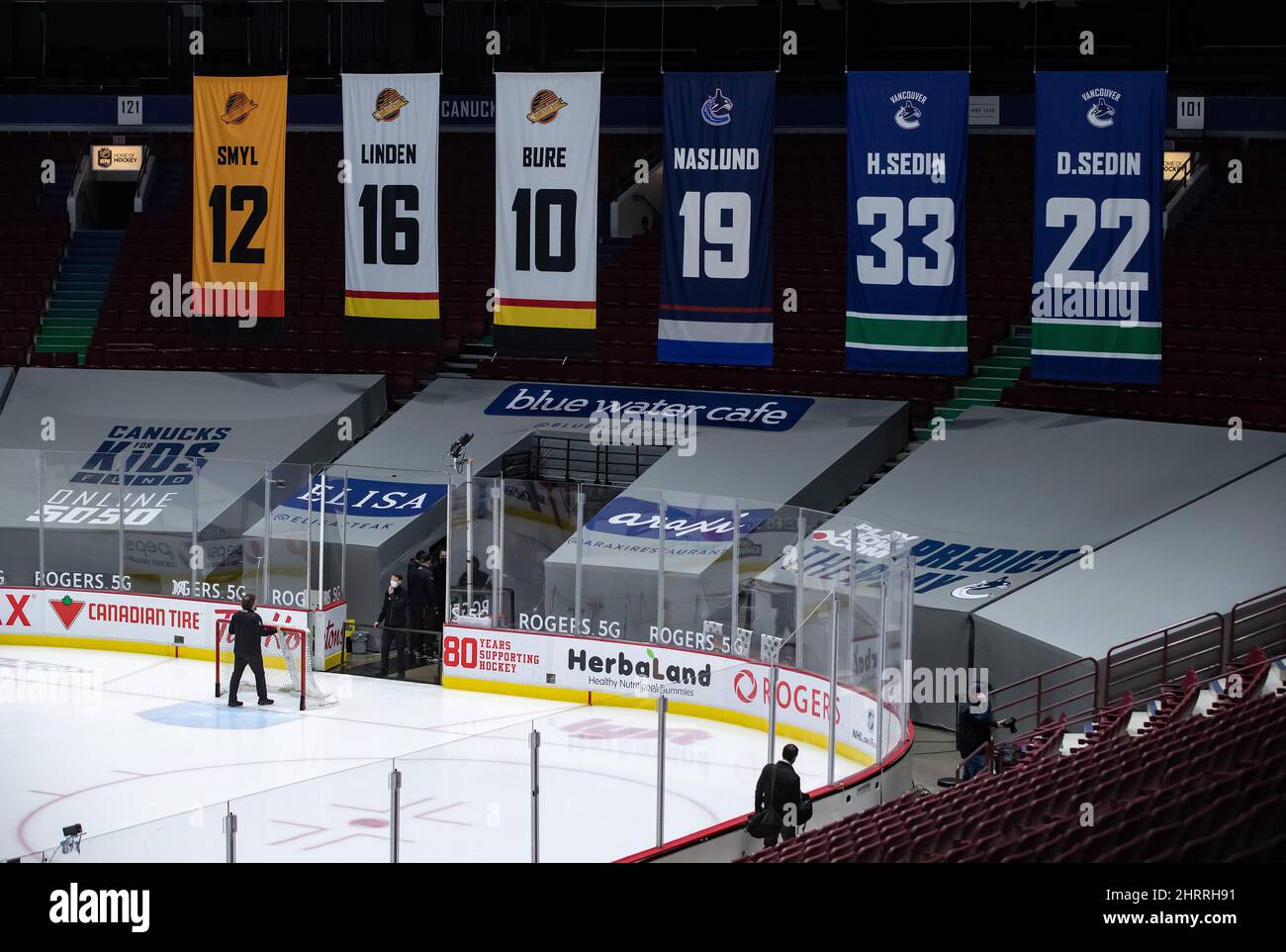 Un de la arena retira la red del hielo después de que el juego de hockey de la NHL Vancouver Canucks y Calgary Flames pospuesto a un resultado positivo