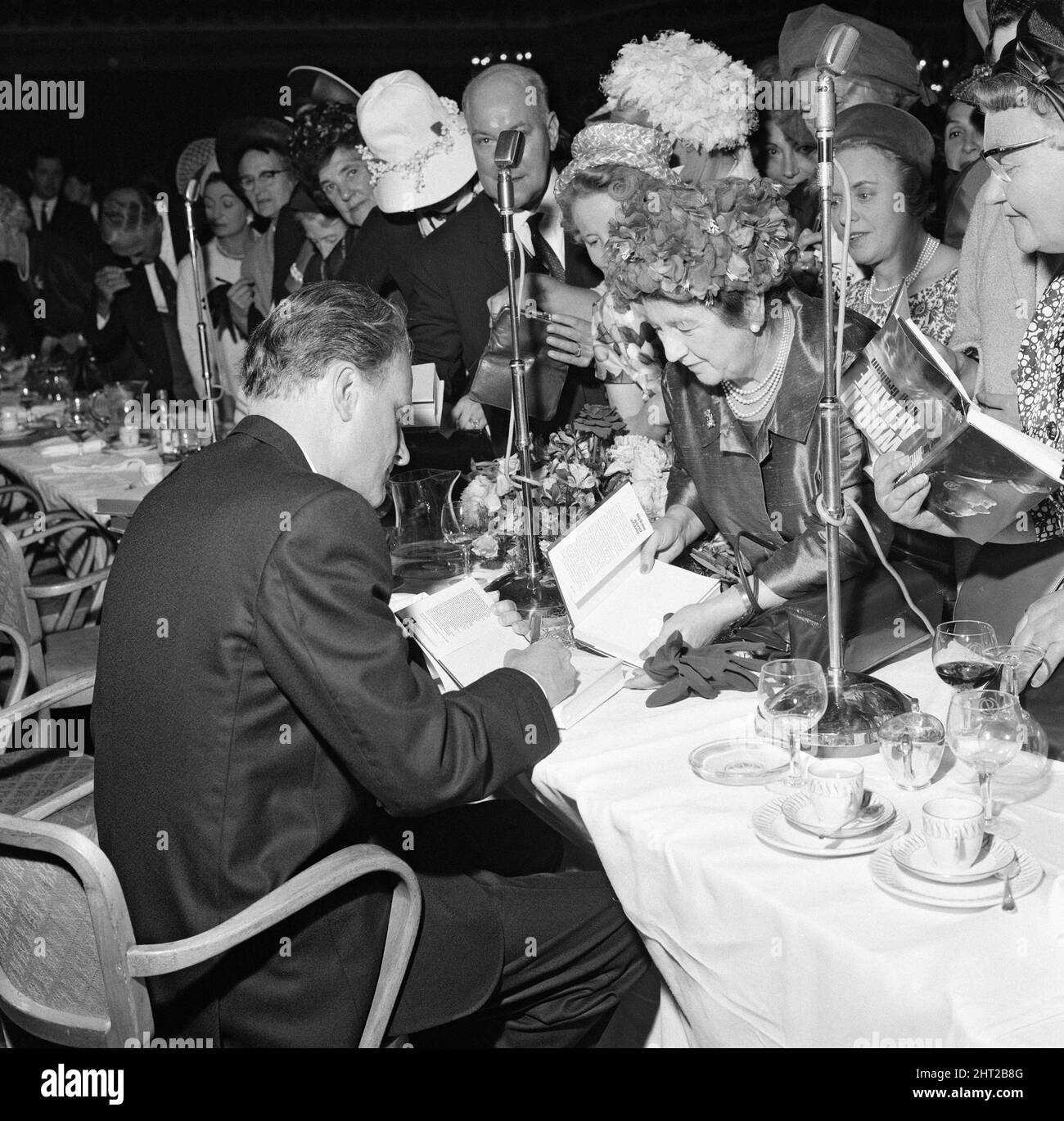 Billy Graham firma copias de su libro 'Llama Mundial' en el almuerzo de alfabetización Foyles, celebrado en el salón de baile Dorchester. El evento se celebró en su honor. 30th de junio de 1966. Foto de stock