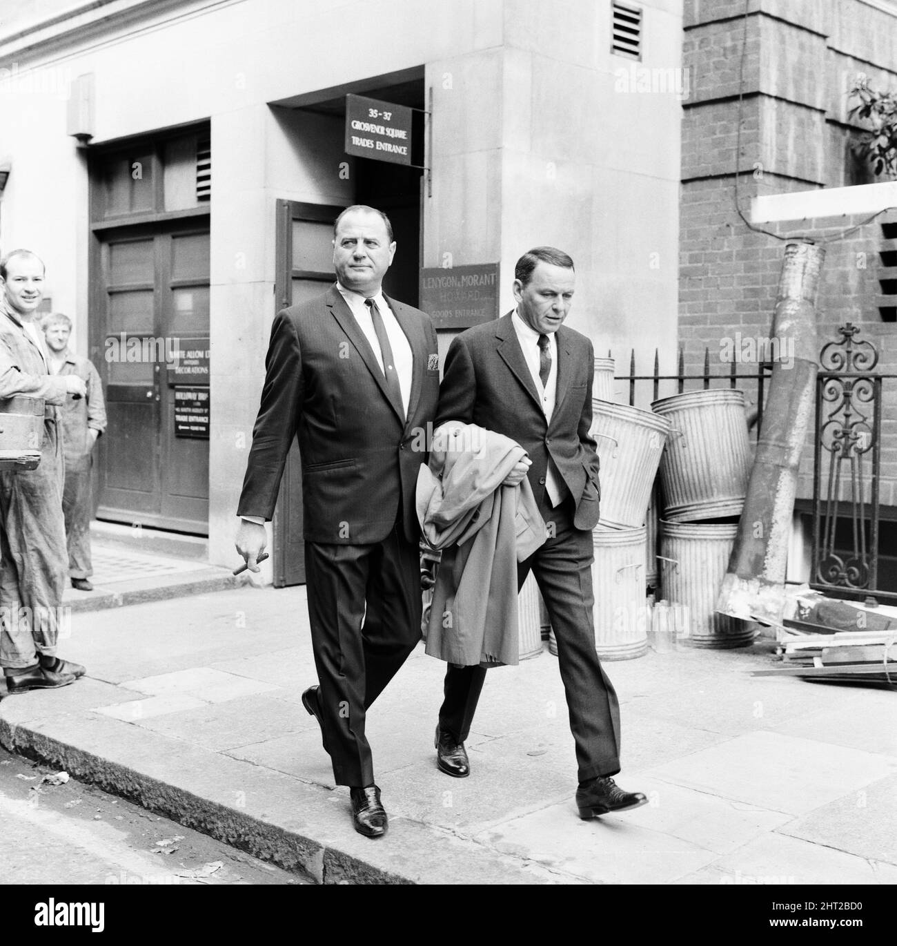 Frank Sinatra, fotografiado con Bradford Dexter, su colega de negocios y ex actor, al salir de su apartamento, a través de la entrada del comerciante, en Grosvenor Square, Londres, 1st de agosto de 1966. Foto de stock