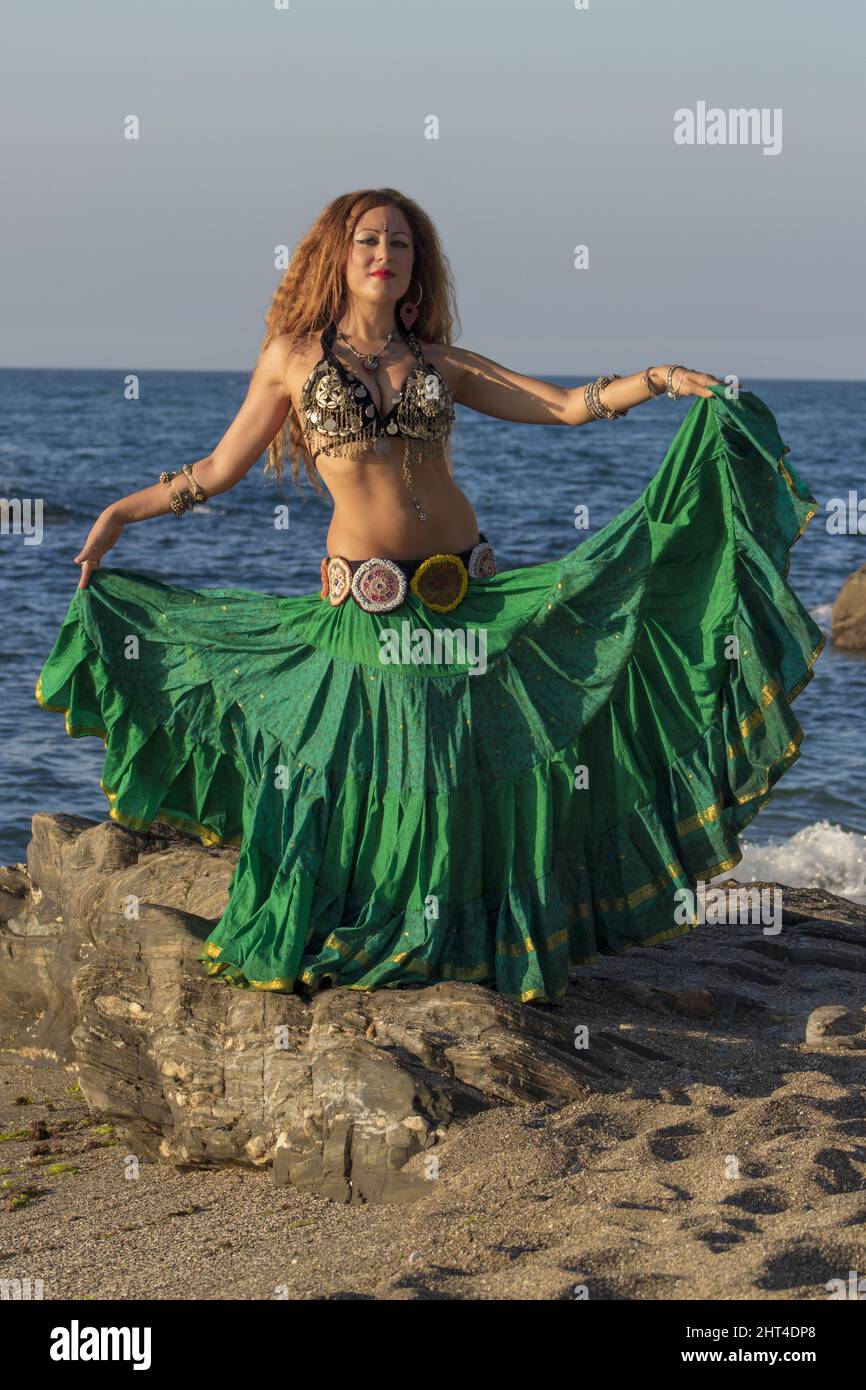 Mujer posando en vestidos de danza del vientre y accesorios en la playa Fotografía de stock