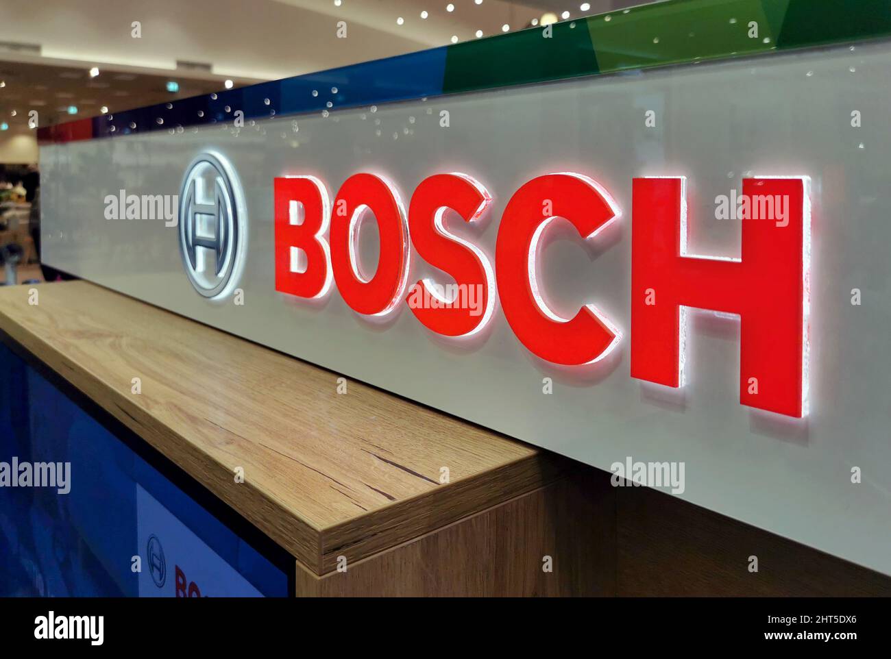 Primer plano de un logotipo de Bosch iluminado en rojo en la tienda de electrodomésticos y electrónica Foto de stock