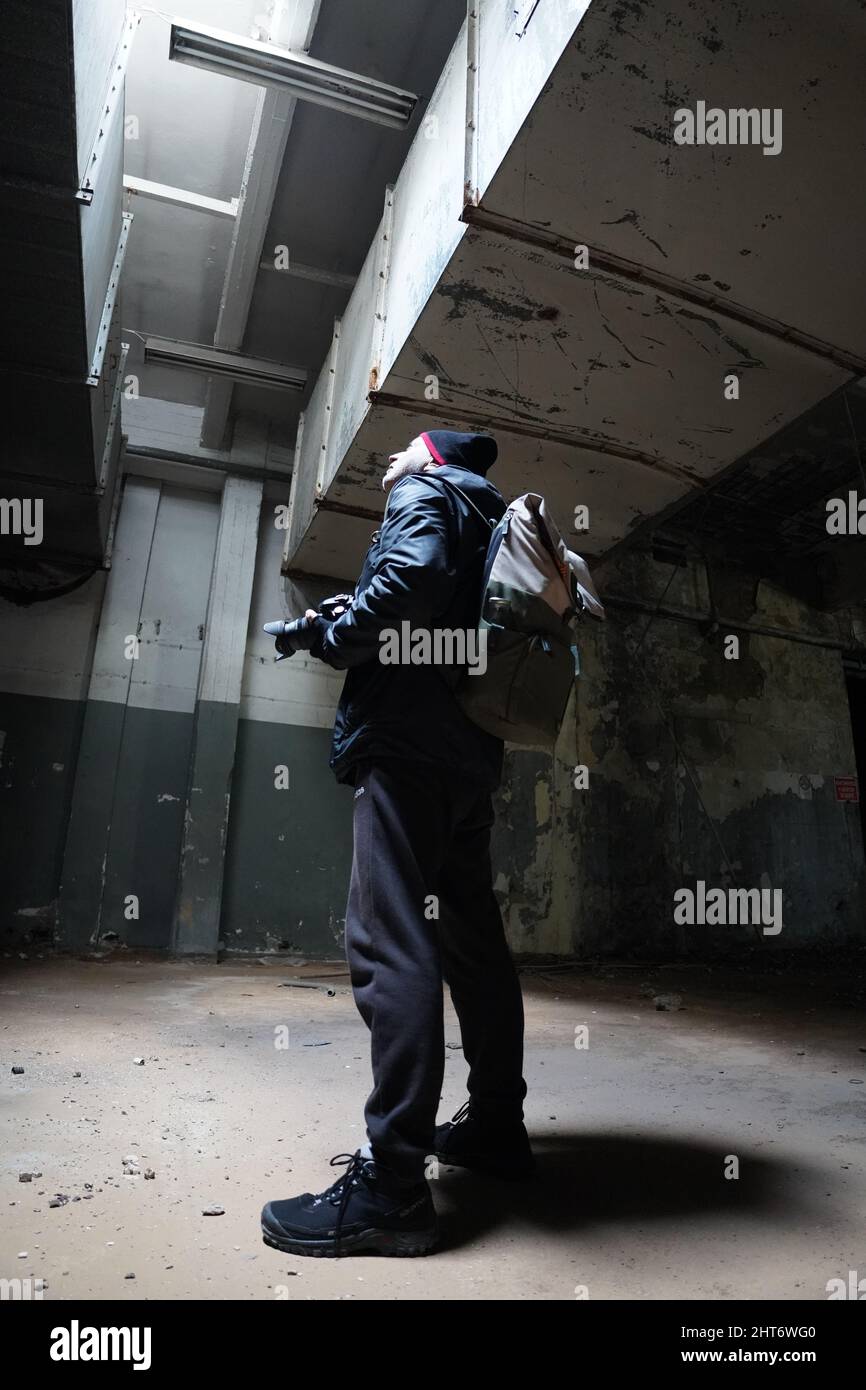 Fotógrafo cámara hombre explorador viajero abandonado edificio sombra luz fantasma ciudad Foto de stock