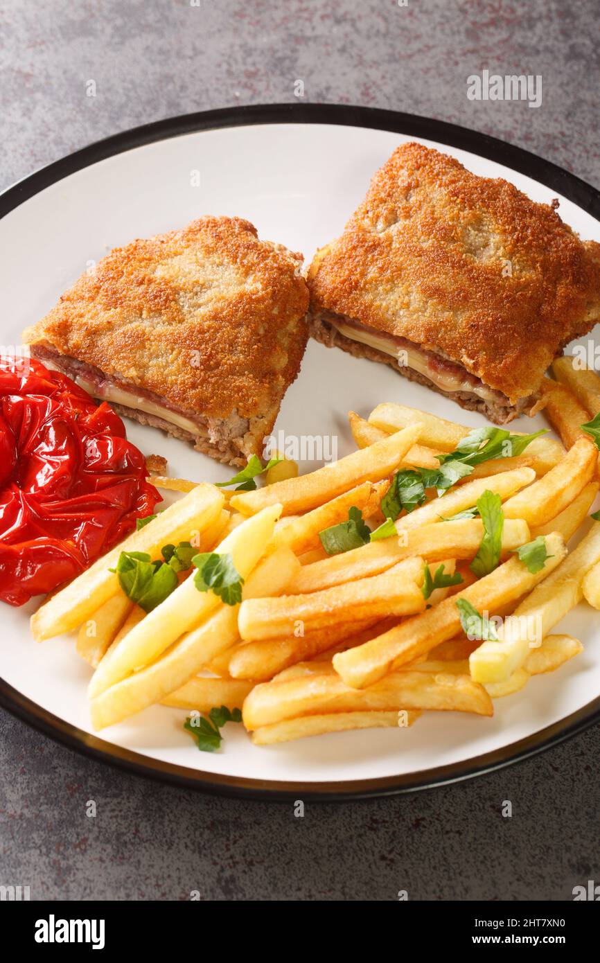 Cachopo es la versión asturiana del Cordón bleu de ternera con patatas  fritas y pimientos asados closeup en el plato blanco de la mesa. Vertical  Fotografía de stock - Alamy