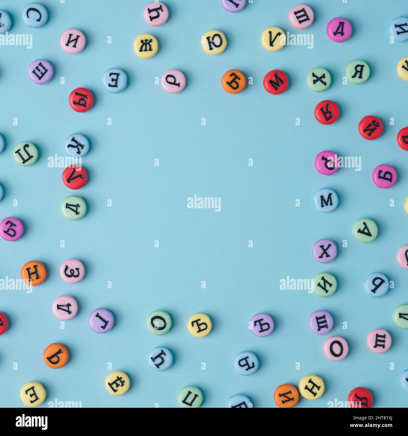 Letras cirílicas botones de colores cuadrados sobre un fondo azul pastel. Rusia, Europa del Este, telón de fondo conceptual. Foto de stock