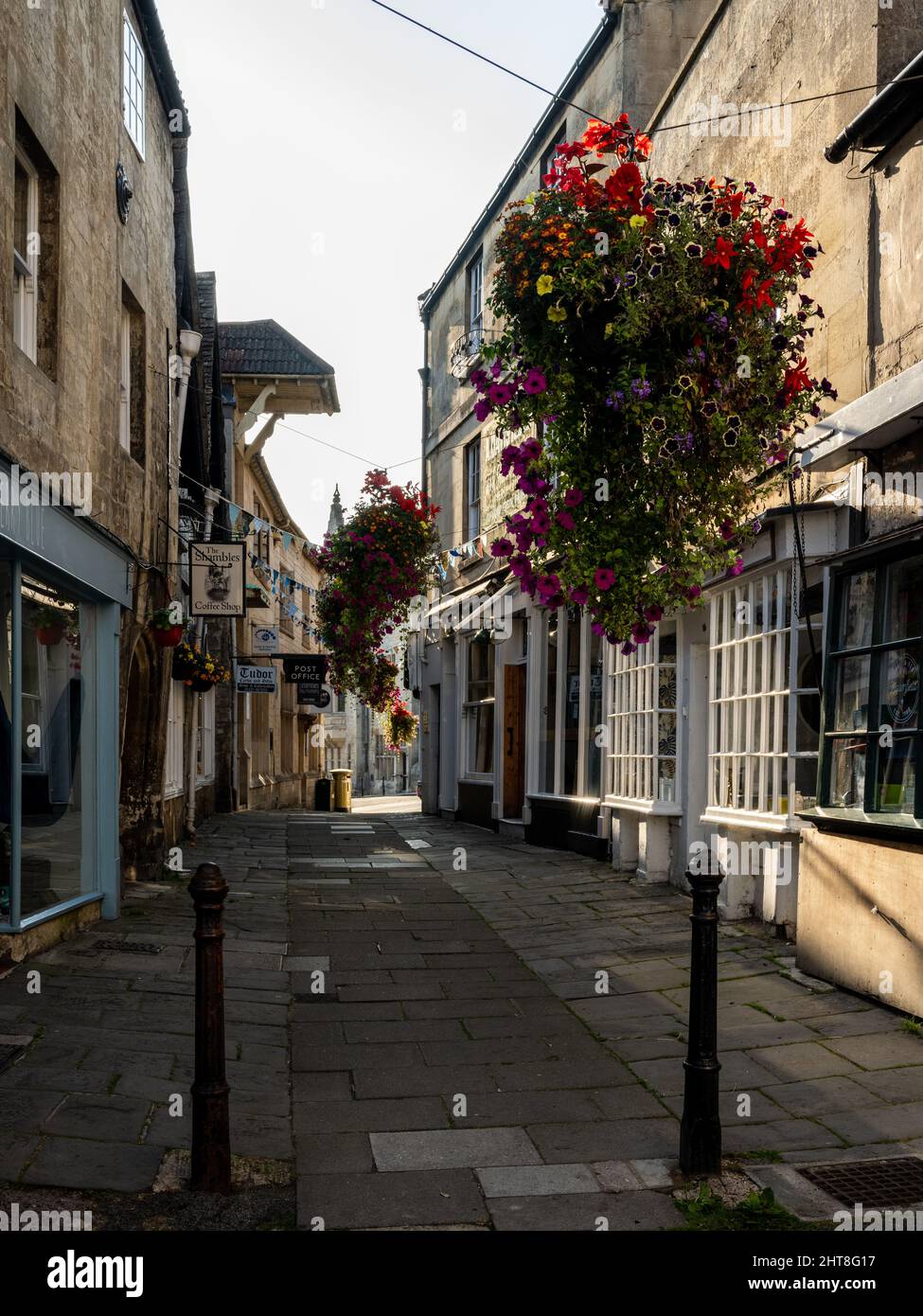 Cestas de flores decoran The Shambles, una calle tradicional de tiendas en Bradford-on-Avon, Wiltshire. Foto de stock