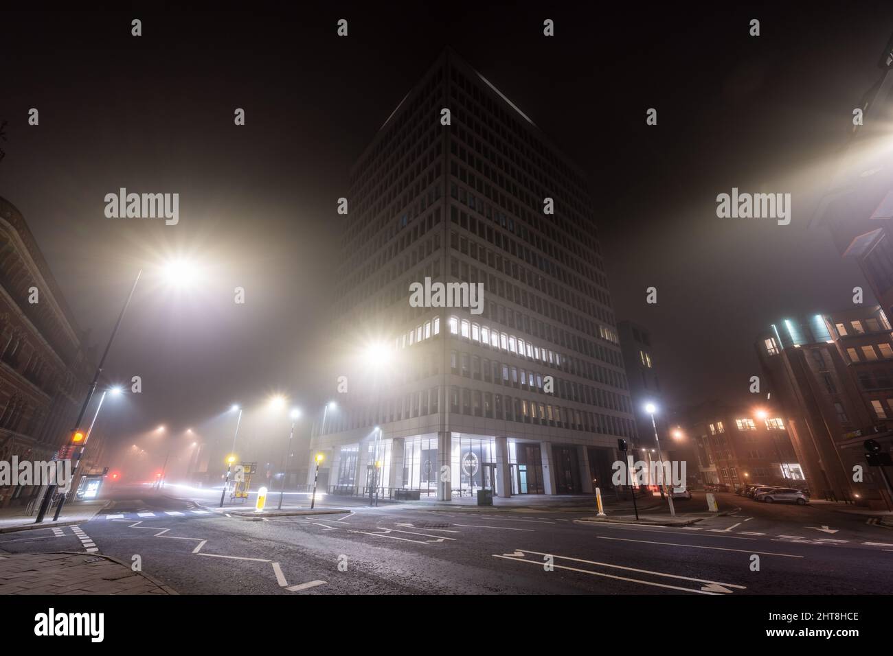 El edificio de oficinas de la calle Redcliff Street, de gran altura, está cubierto de niebla en una noche de invierno en la calle Victoria Street de Bristol. Foto de stock