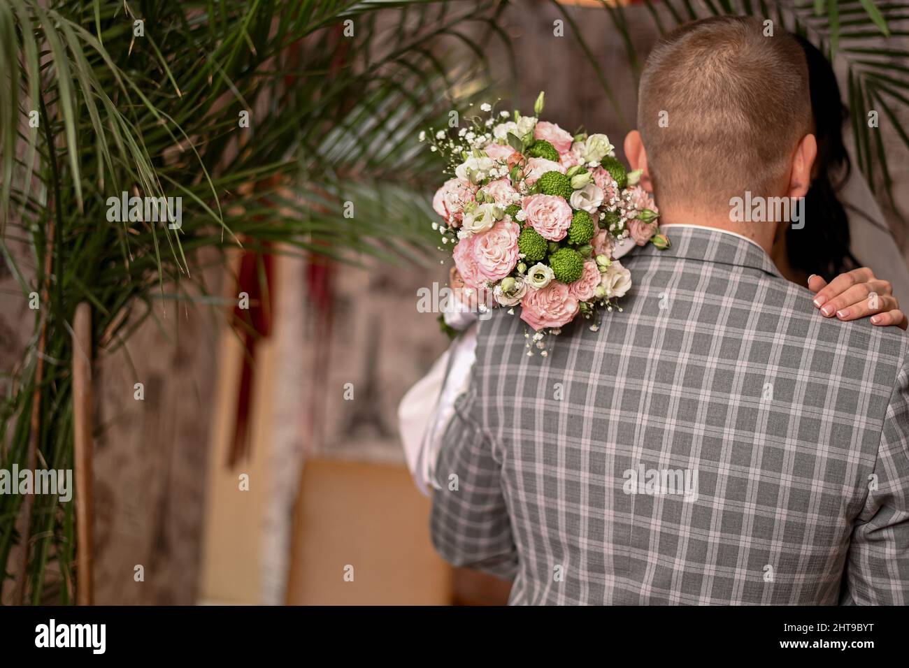 el novio abrazó a la novia. ramo de boda en las manos de la novia. Foto de stock