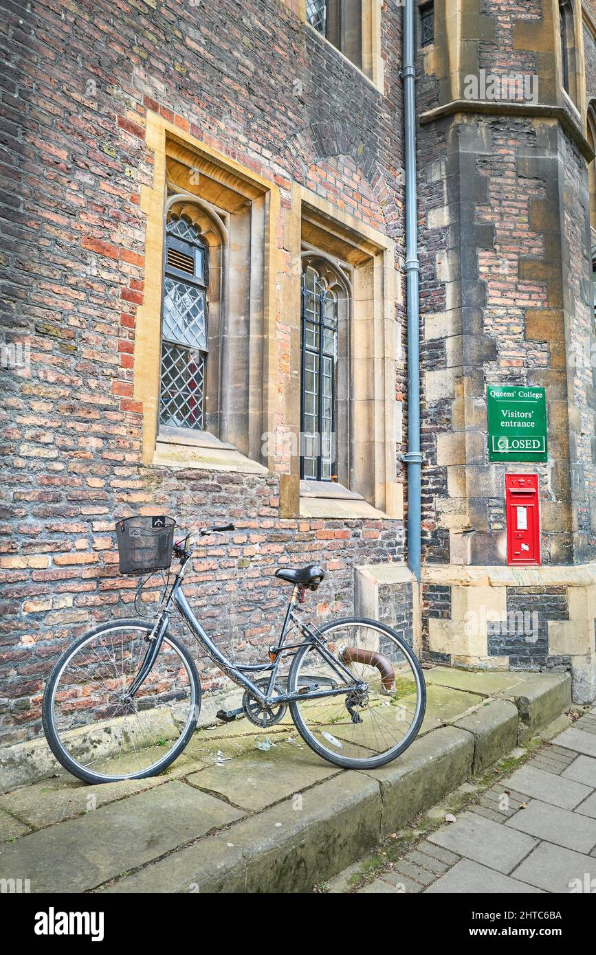 Una bicicleta aparcada fuera de la entrada cerrada para visitantes del Queens' College, universidad de Cambridge, Inglaterra. Foto de stock