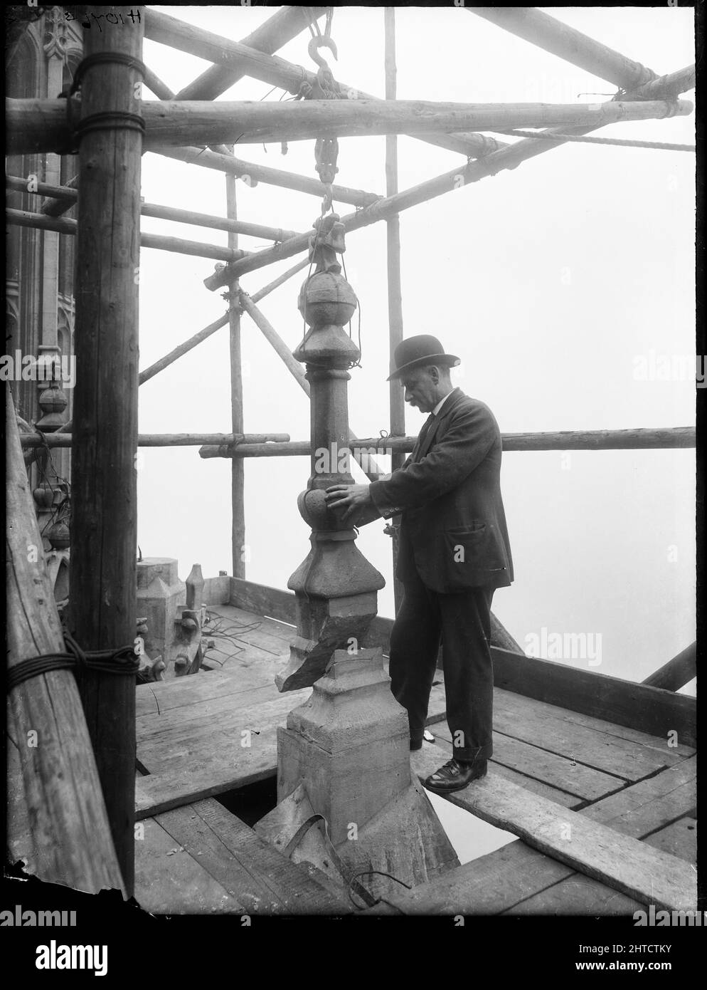 Victoria Tower, Palace of Westminster, Westminster, Londres, c1925-1935. Un hombre guiando un pedazo de piedra en su lugar en la cima de la Torre Victoria en el Palacio de Westminster, durante las obras de restauración. Foto de stock