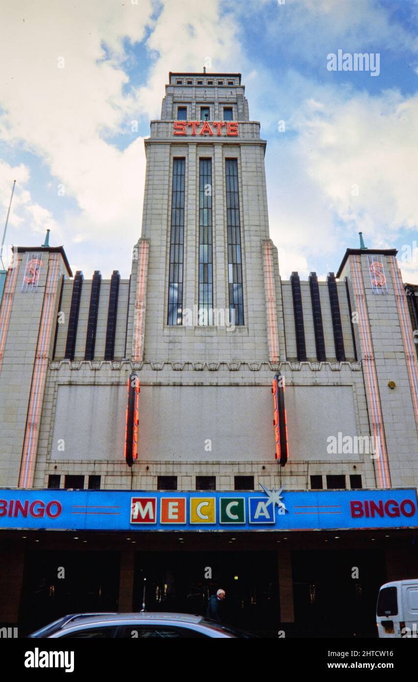 Mecca Bingo Club, Kilburn High Road, Kilburn, Brent, Londres, 1990-2004. La elevación noreste del Club de Bingo de La Meca. El Teatro Estatal Gaumont fue inaugurado en 1937. Fue uno de los cines más grandes de Europa, y el más grande de Inglaterra, con una capacidad de 4.004 asientos. El diseño exterior se inspira en el Empire State Building de Nueva York. El edificio fue dividido más tarde en una sala de baile, cine y sala de bingo, antes de ser utilizado únicamente como sala de bingo desde alrededor de 1990. En 2010 el edificio se reabrió como una iglesia. Foto de stock