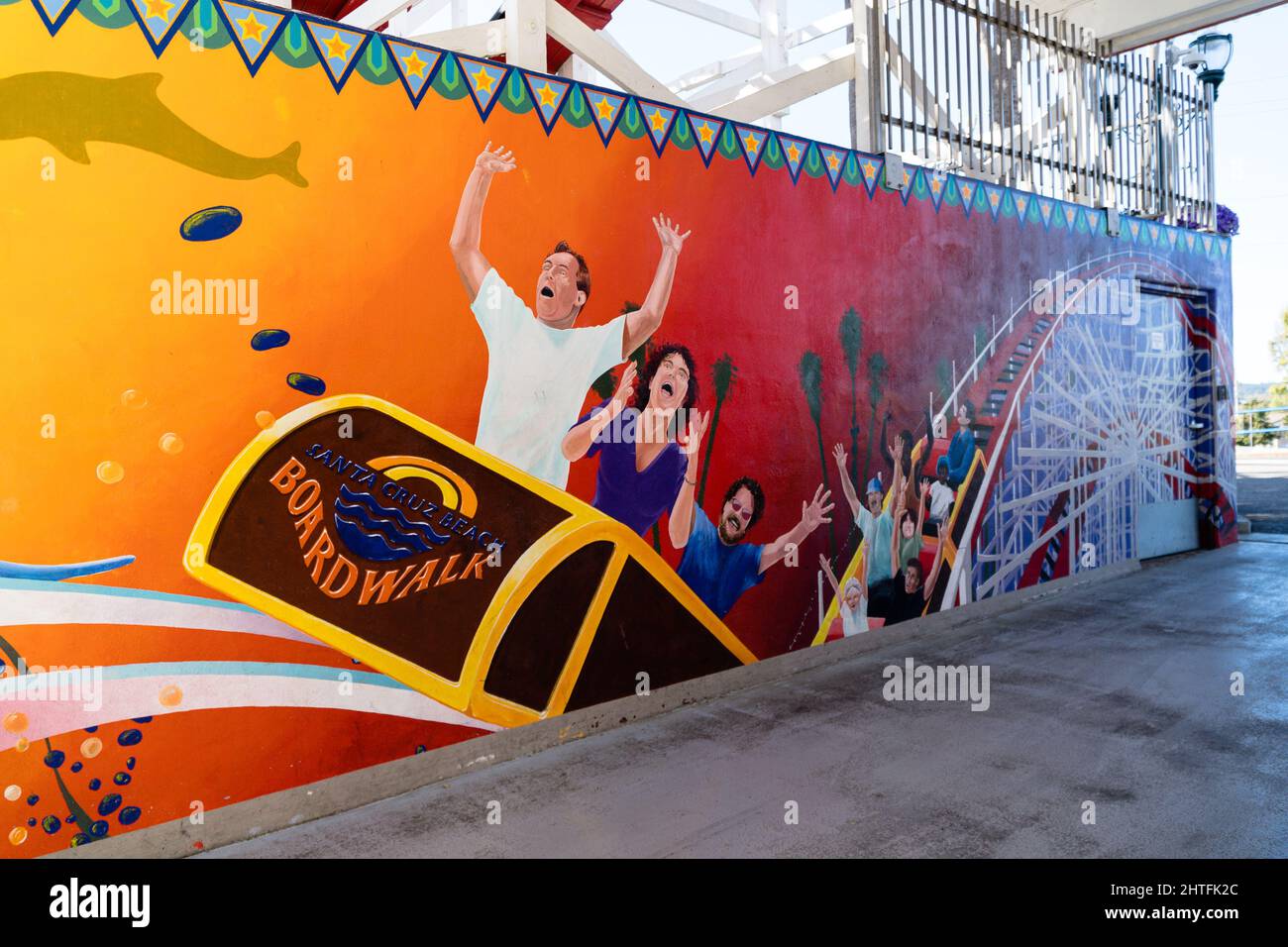 Una vista de Santa Monica Board Walk Wall pintada con graffiti con turistas en una montaña rusa, California Foto de stock