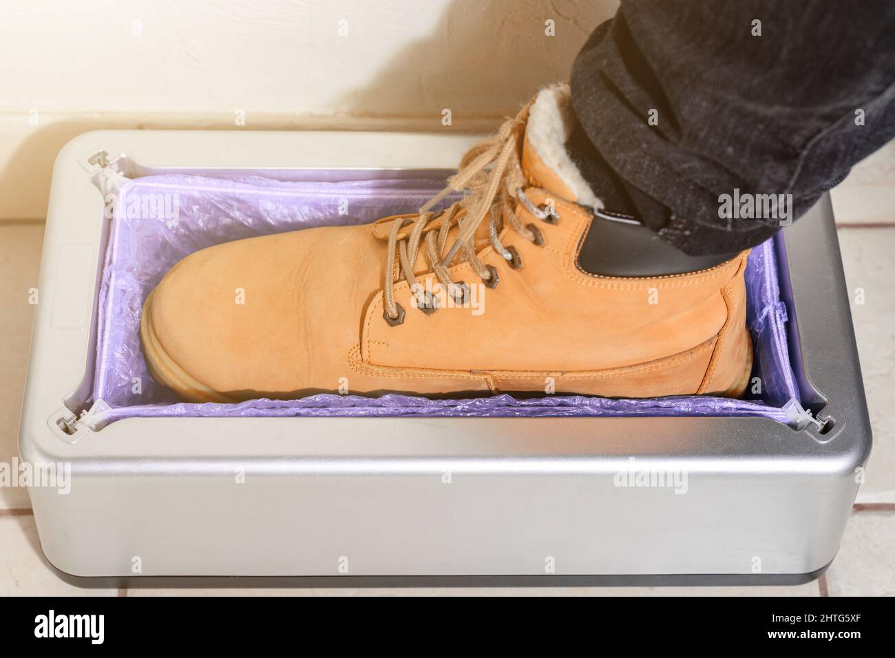 Dispositivo para el vendaje automático de las cubiertas de las botas, un  hombre en zapatos marrones pone las cubiertas de las botas, clintoper  mecánico Fotografía de stock - Alamy