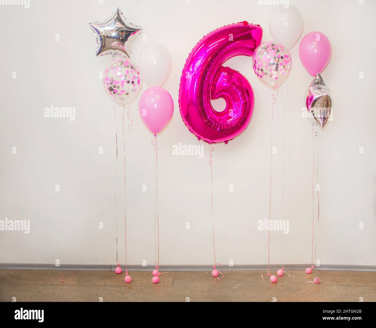 Felicitaciones por la celebración del sexto aniversario de su nacimiento. Número 6 globo y globos de color rosa metalizado. Feliz cumpleaños, póster de saludo. Foto de stock