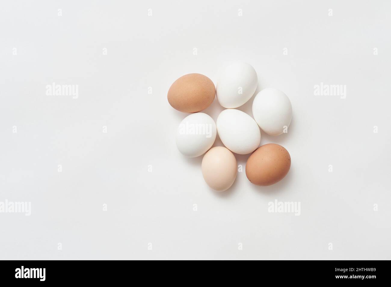 Varios huevos de pollo sobre fondo de papel blanco Foto de stock