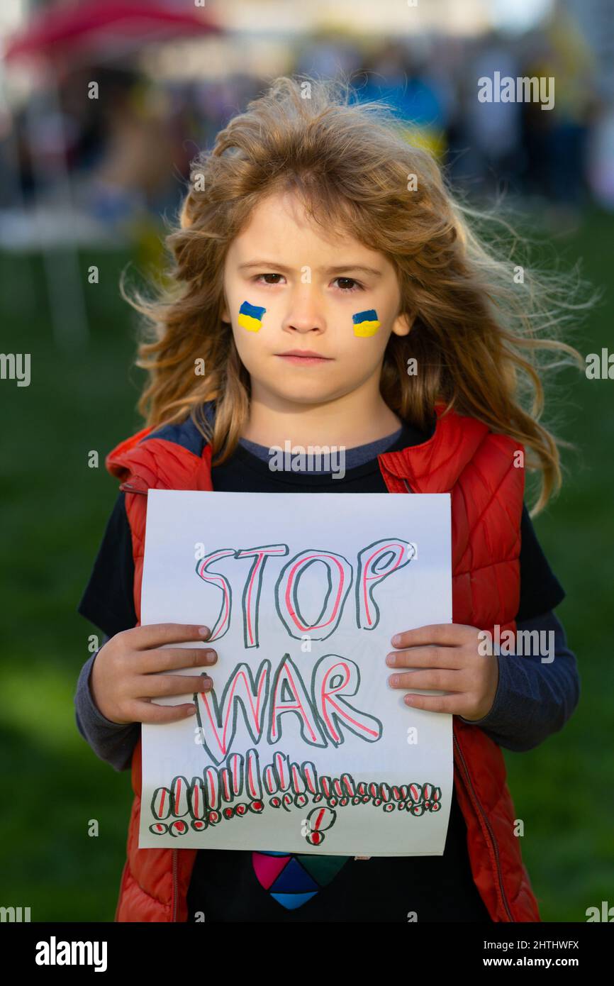 Niño pequeño sosteniendo un cartel con mensaje de Stop war, activismo y movimiento de derechos humanos, estilo de vida al aire libre. Foto de stock