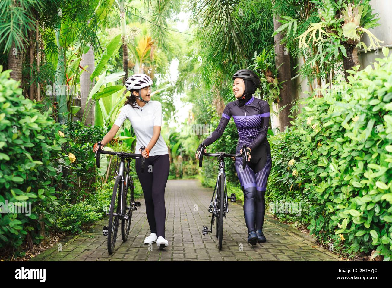 dos mujeres ciclistas musulmanas empujan su bicicleta y hablan Fotografía  de stock - Alamy