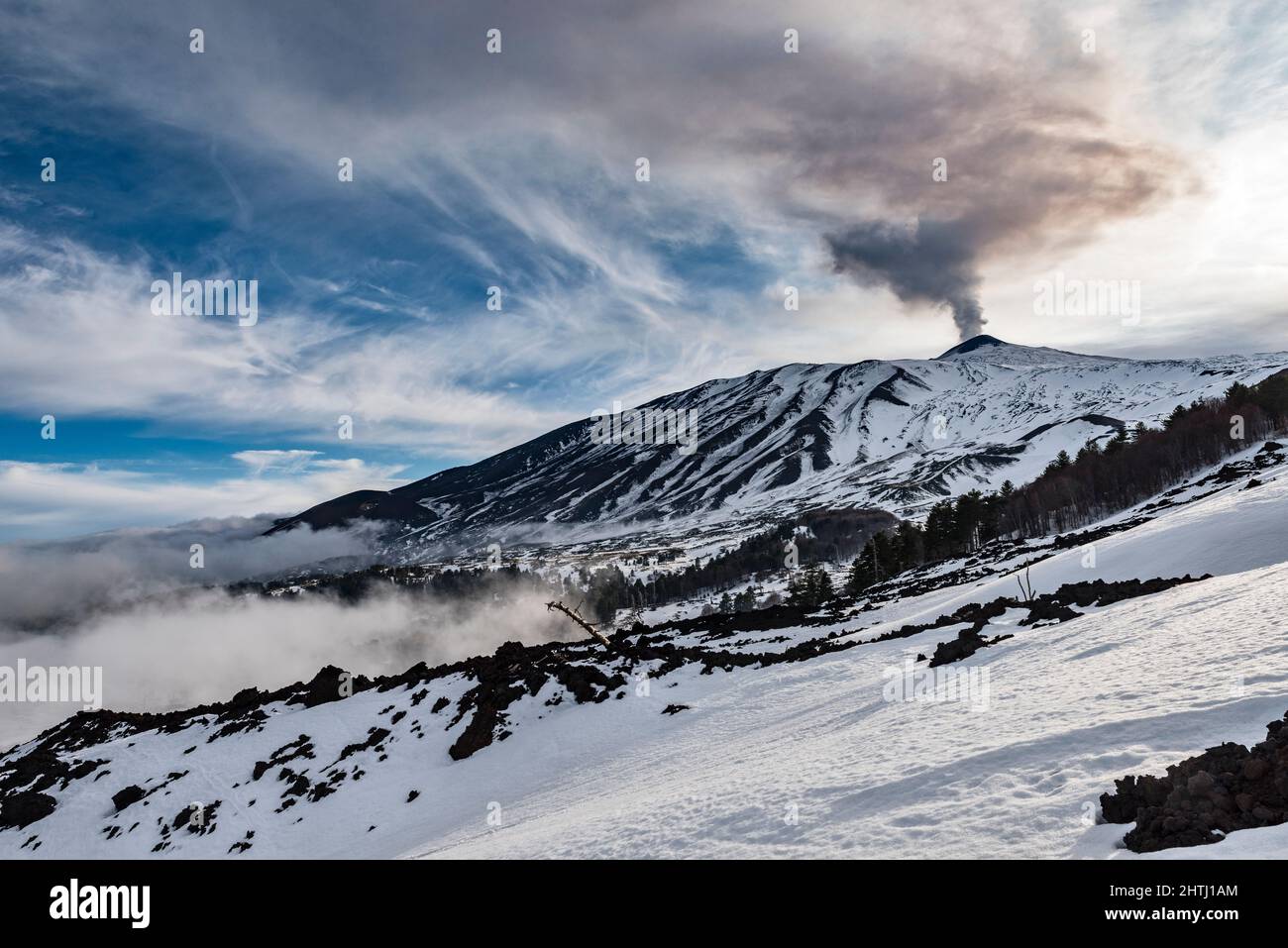 La cumbre del Monte Etna (3357m), Sicilia, Italia, vista a finales de invierno con el humo que vierte del cráter actualmente activo del sureste Foto de stock