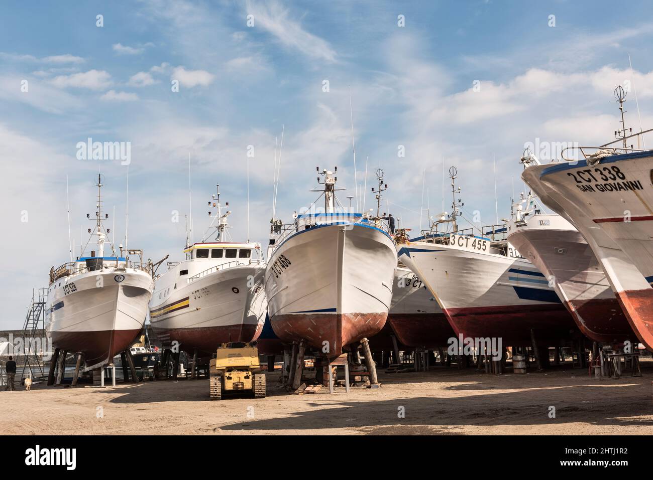 Barcos de pesca en muelle seco para mantenimiento y reparación durante el invierno, en el puerto de Riposto, Sicilia, Italia Foto de stock