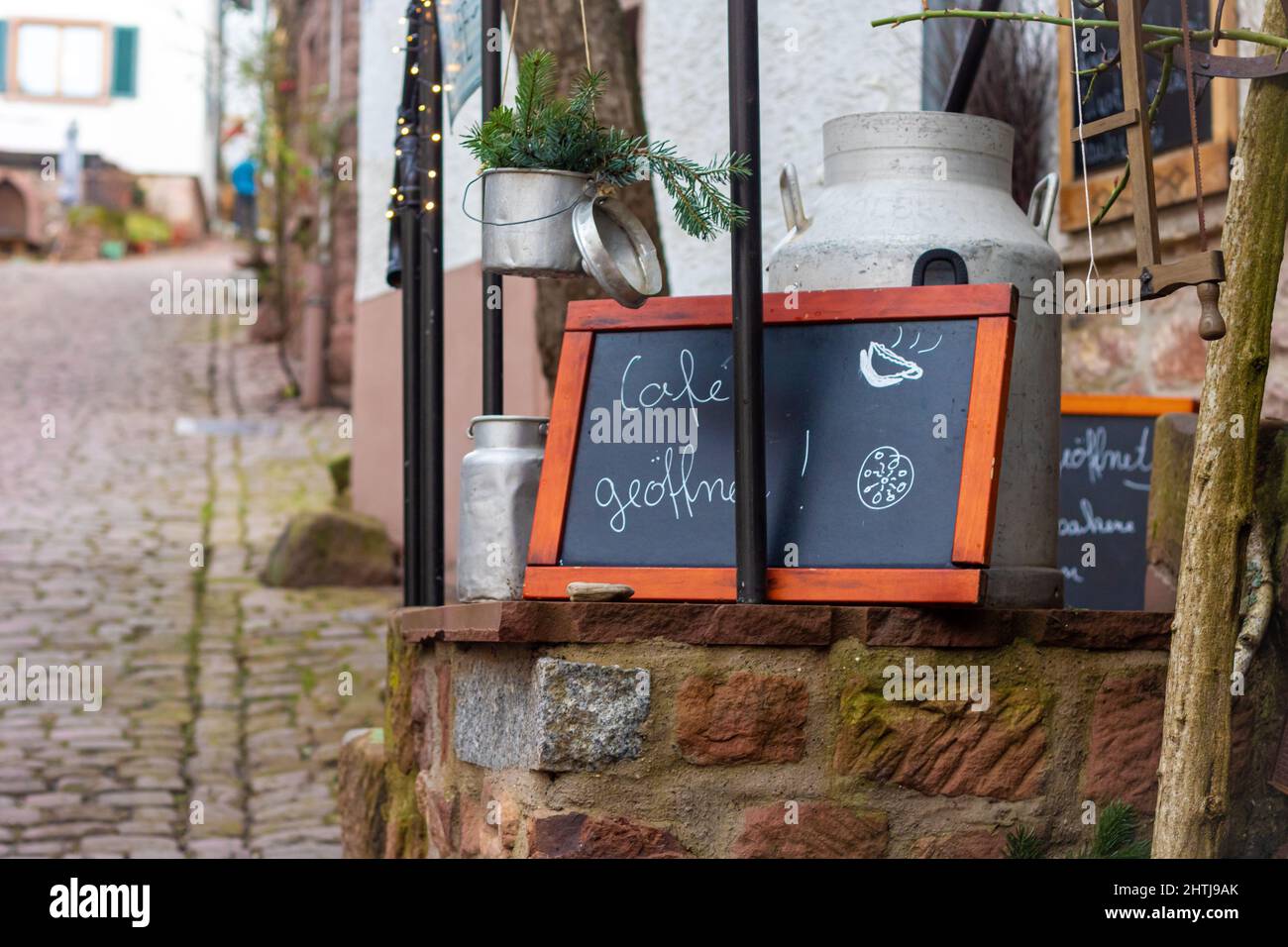 pizarra con el mensaje escrito a mano con las palabras alemanas para café abierto en frente de un pequeño restaurante en un casco antiguo alemán. Foto de stock