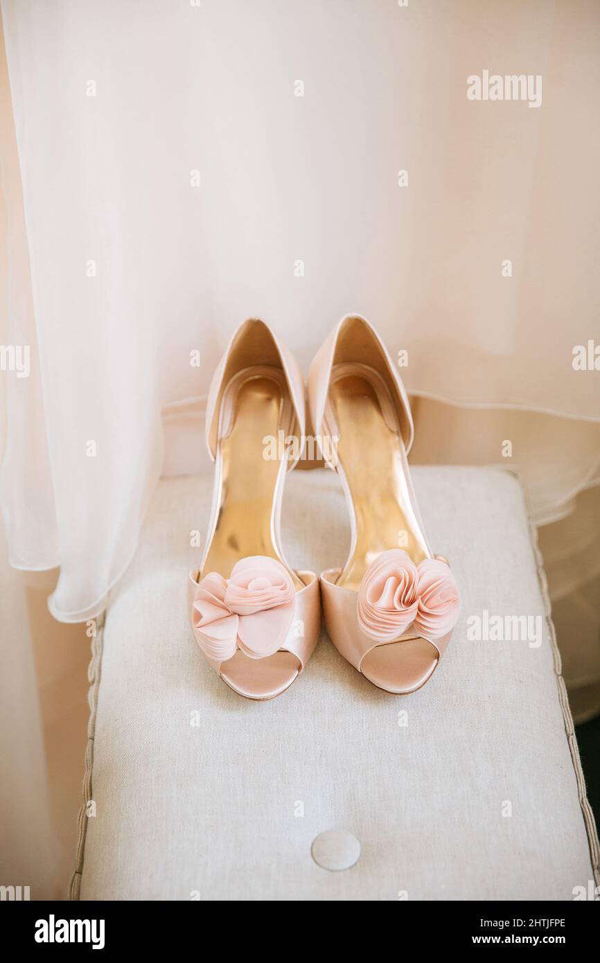 Desde la parte superior de los zapatos beige de tacón alto con estilo de  color rosa para la novia colocado en la mesa blanca cerca del vestido de  boda Fotografía de stock -