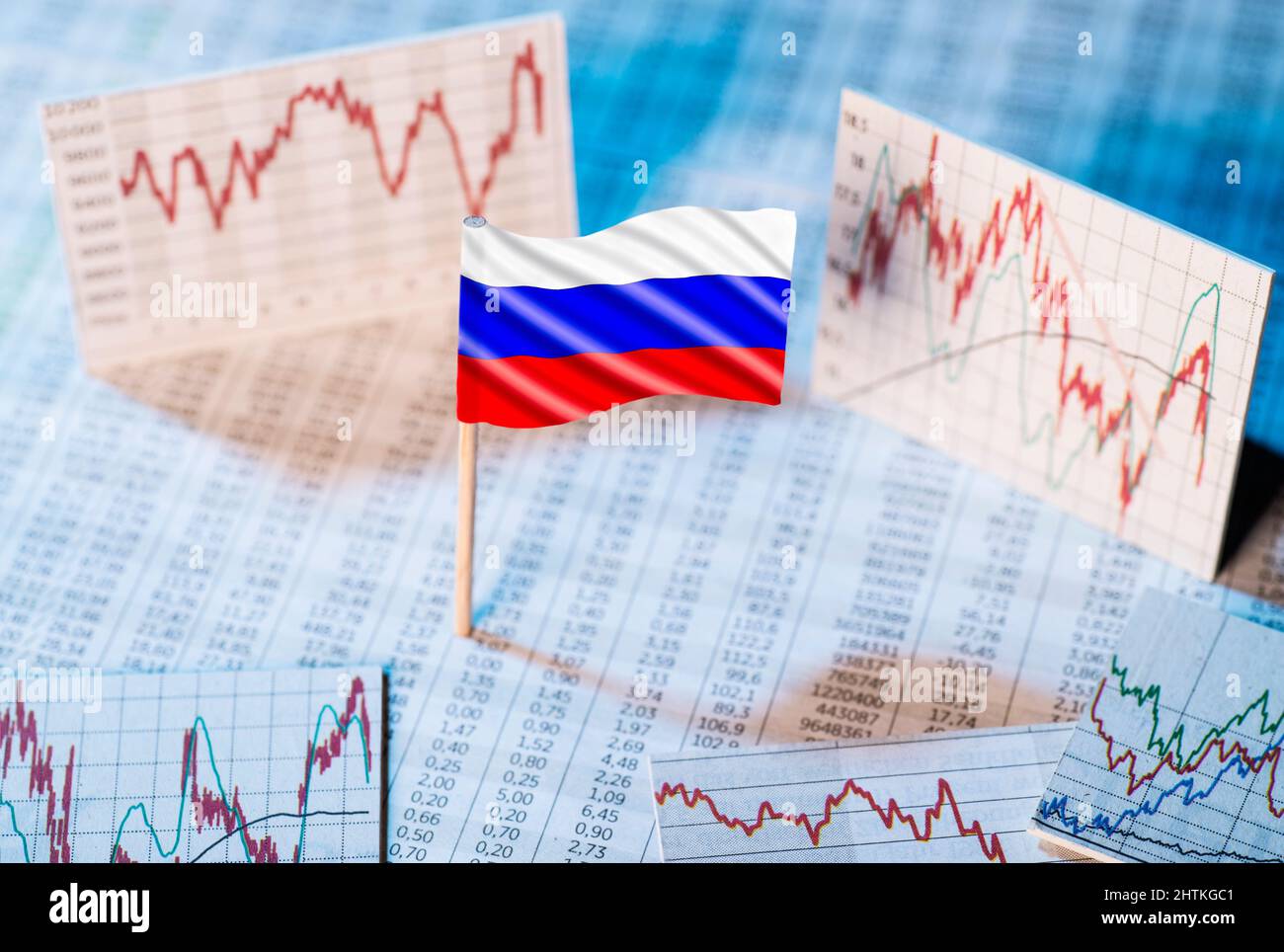 Bandera rusa con tablas de tipos de cambio y gráficos de desarrollo económico Foto de stock
