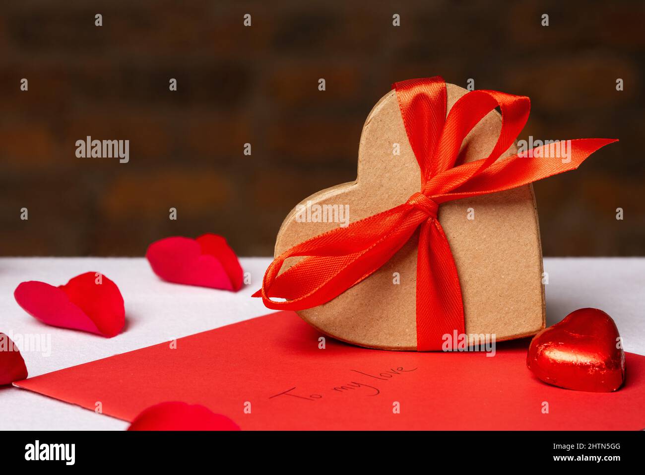Caja de regalo con forma de corazón y adornos para el Día de San Valentín en  la mesa Fotografía de stock - Alamy