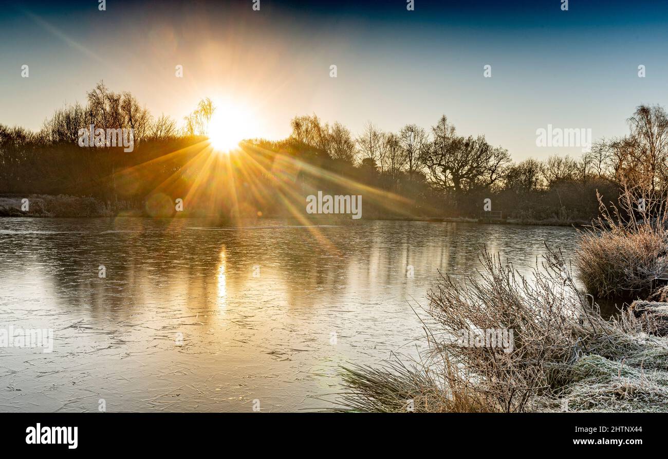 Amanecer sobre un lago congelado. Bulwell Hall Park Nottingham, Inglaterra, Reino Unido Foto de stock