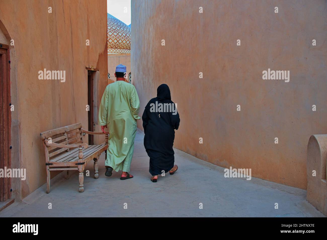 Pareja con ropa árabe tradicional en la calle en la parte antigua de Nizwa, Omán Foto de stock