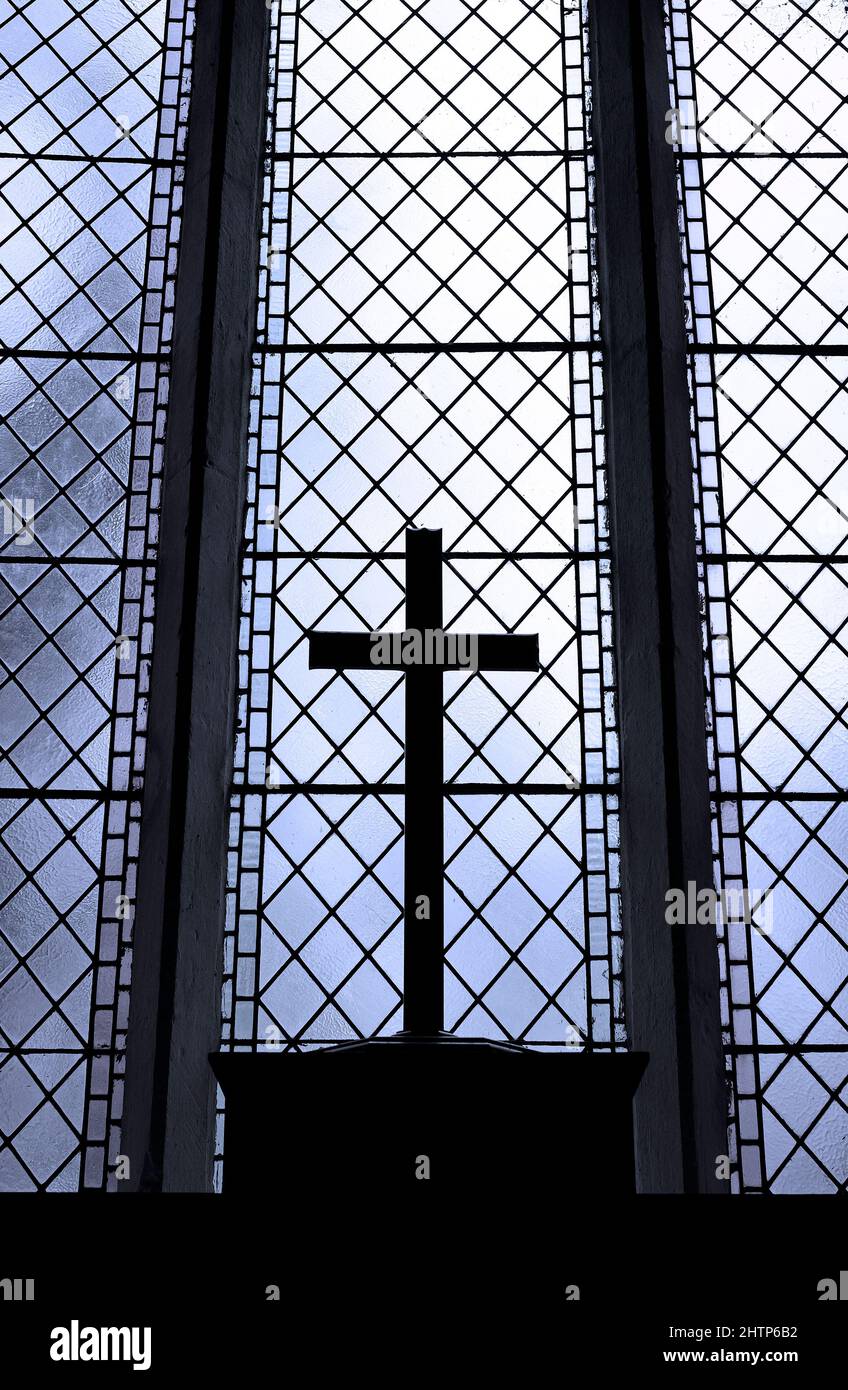 cruz retroiluminada en ventana de iglesia con plomo, norfolk, inglaterra Foto de stock