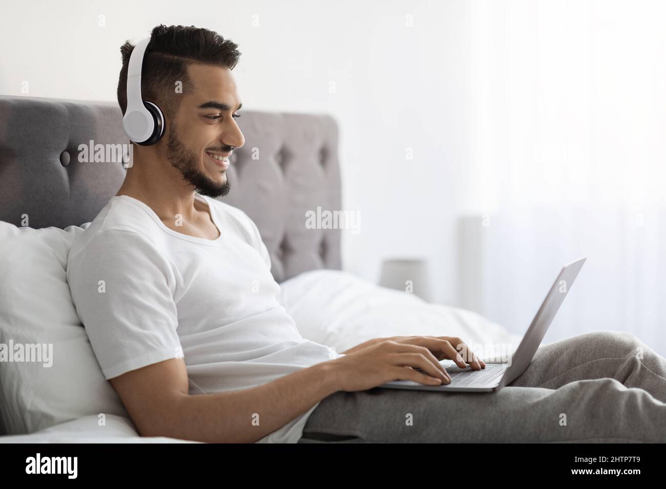 Hombre árabe joven deportivo con auriculares inalámbricos con