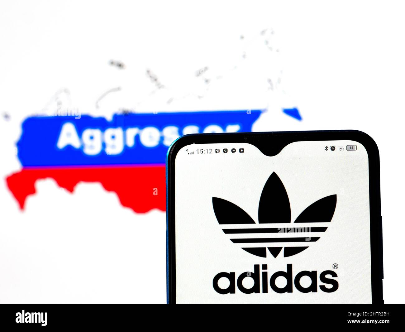 En esta ilustración de la foto, el logotipo de Adidas se muestra en una  pantalla de smartphone con una bandera de Rusia en forma de mapa del país  con la inscripción del
