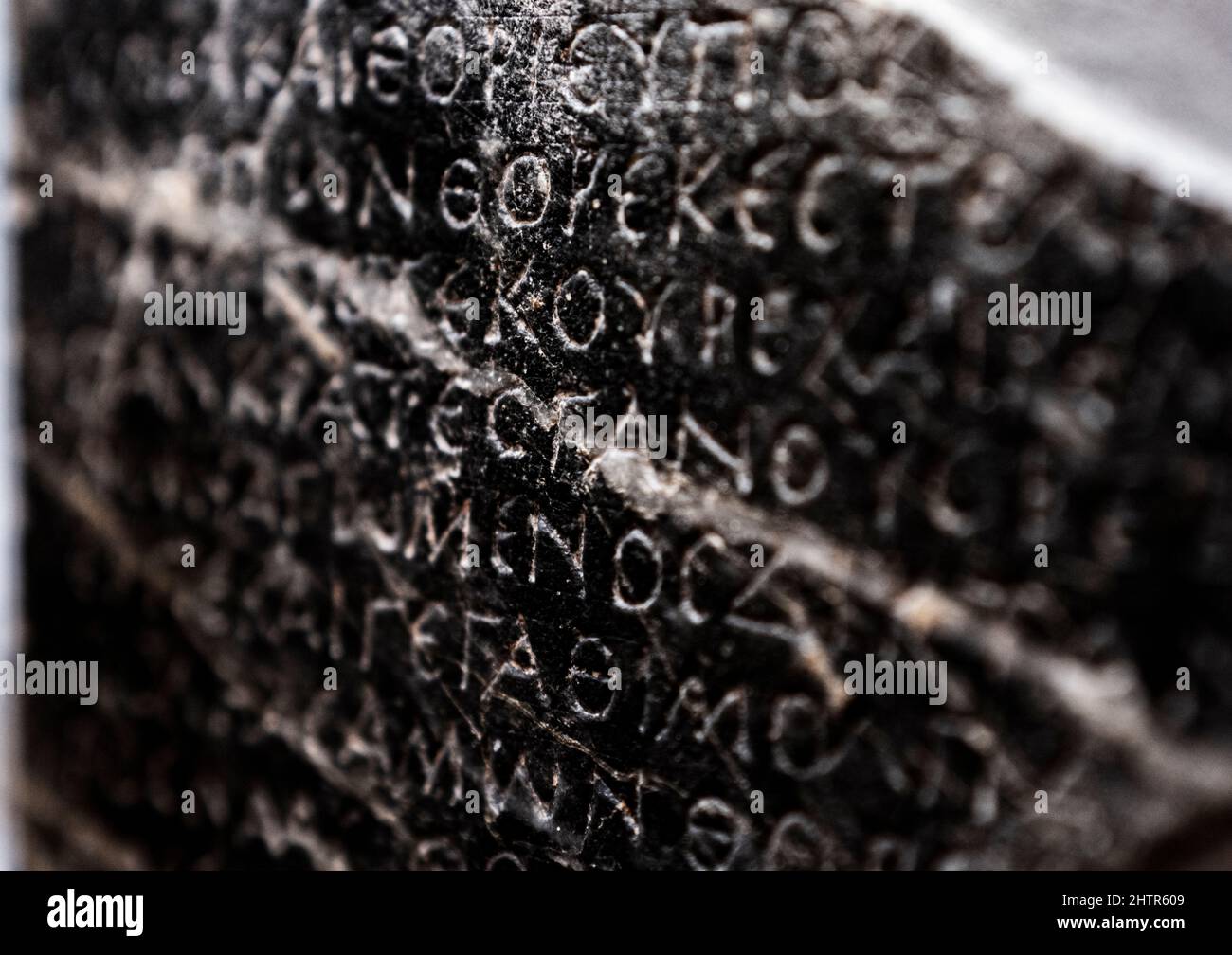 Inscripciones en griego antiguo talladas en una roca volcánica negra, Museo Arqueológico de Heraklion, isla de Creta, Grecia Foto de stock