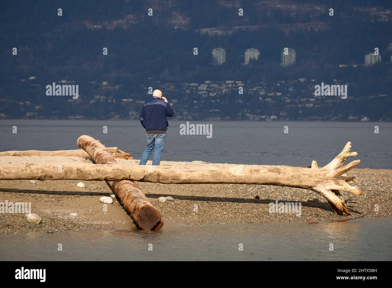 Hombre hablando en su celular al aire libre, Jericho Beach, Vancouver, BC, Canadá Foto de stock