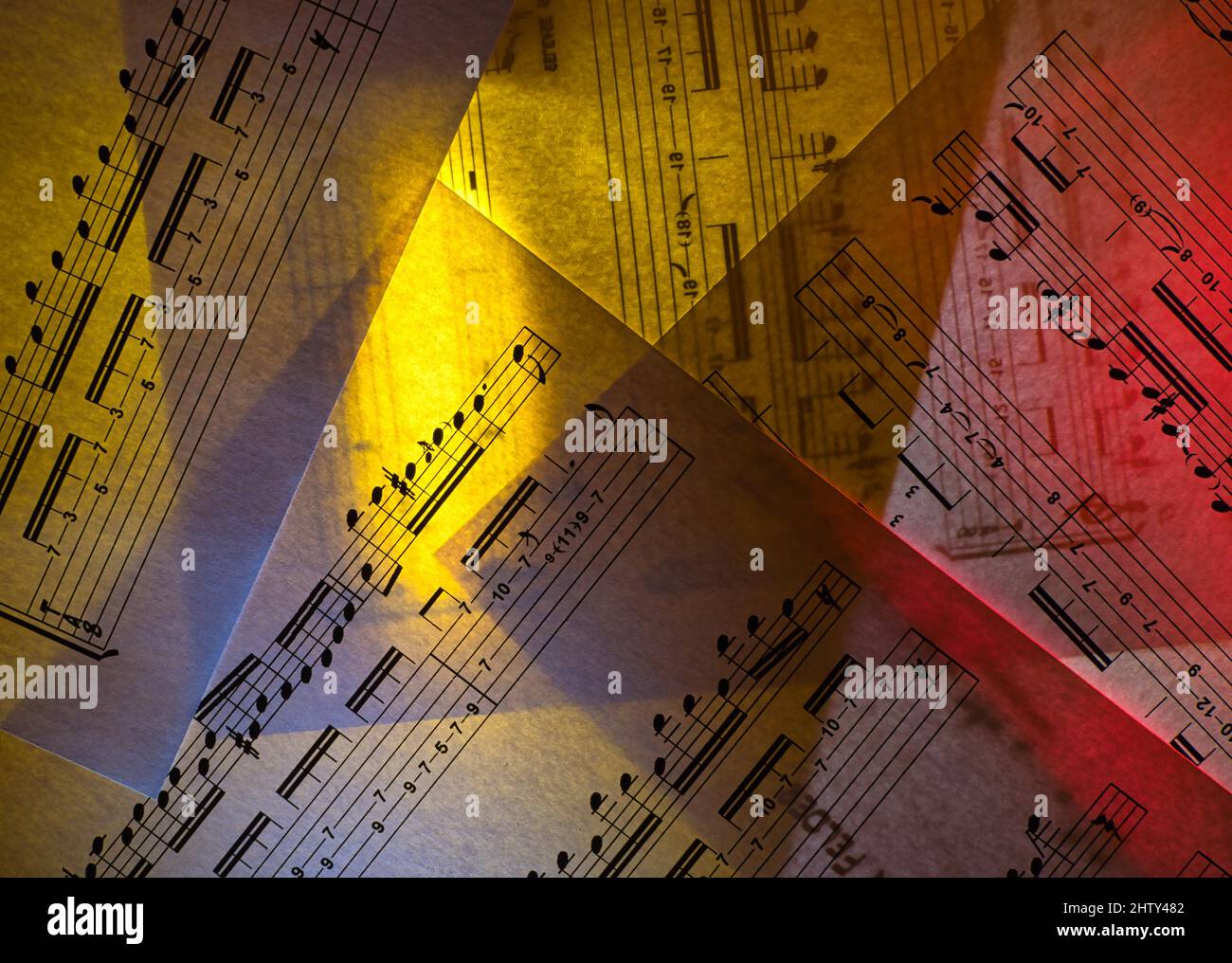 Partituras para guitarra, iluminadas desde atrás con luz amarilla y roja Foto de stock