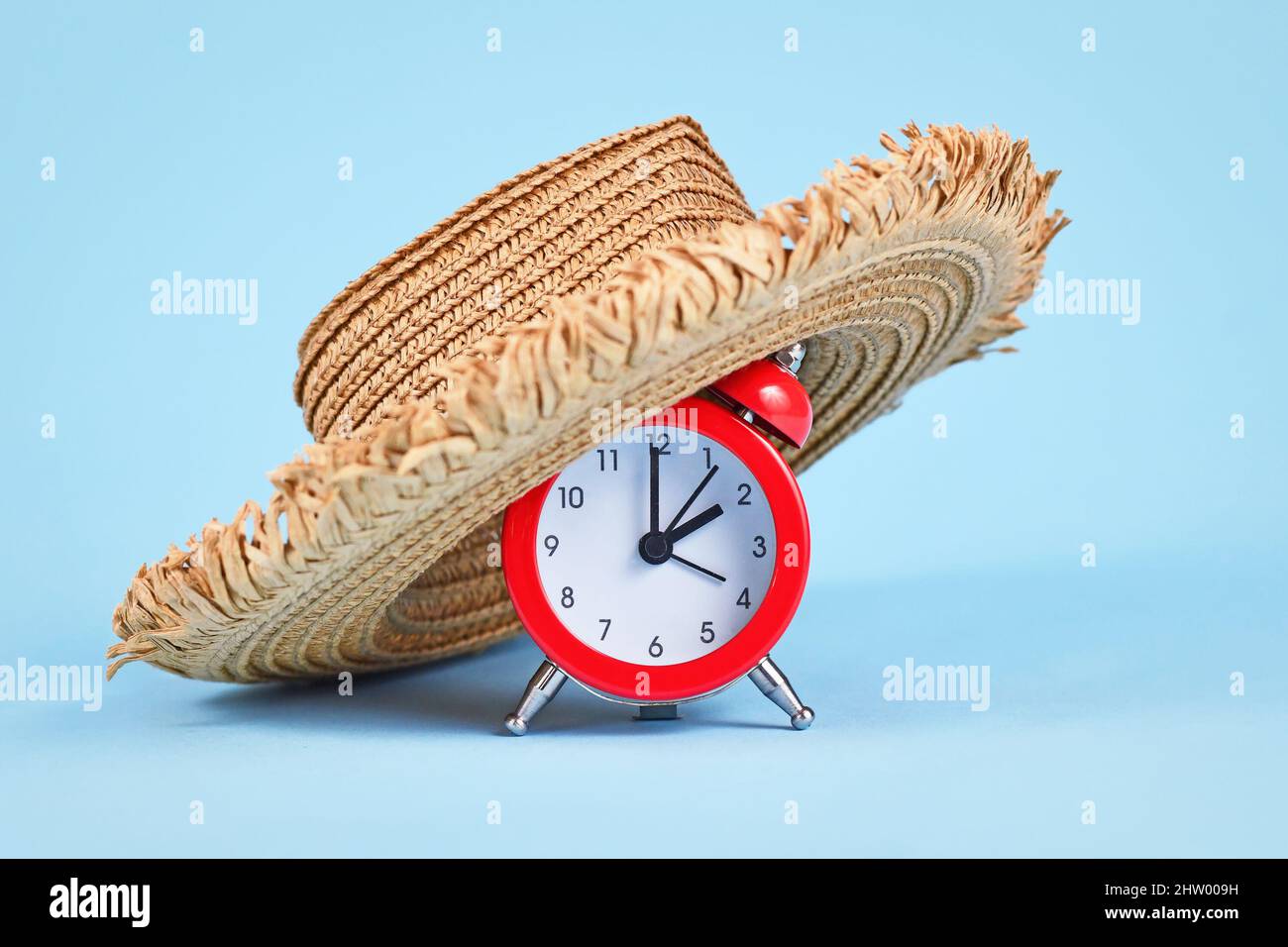 Concepto para el horario de verano en Europa con reloj despertador con sombrero de paja Foto de stock