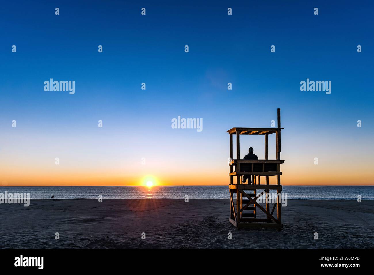 Una persona solitaria observa el amanecer en el océano, Cape Cod National Seashore, Orleans, Cape Cod, Massachusetts, Estados Unidos. Foto de stock