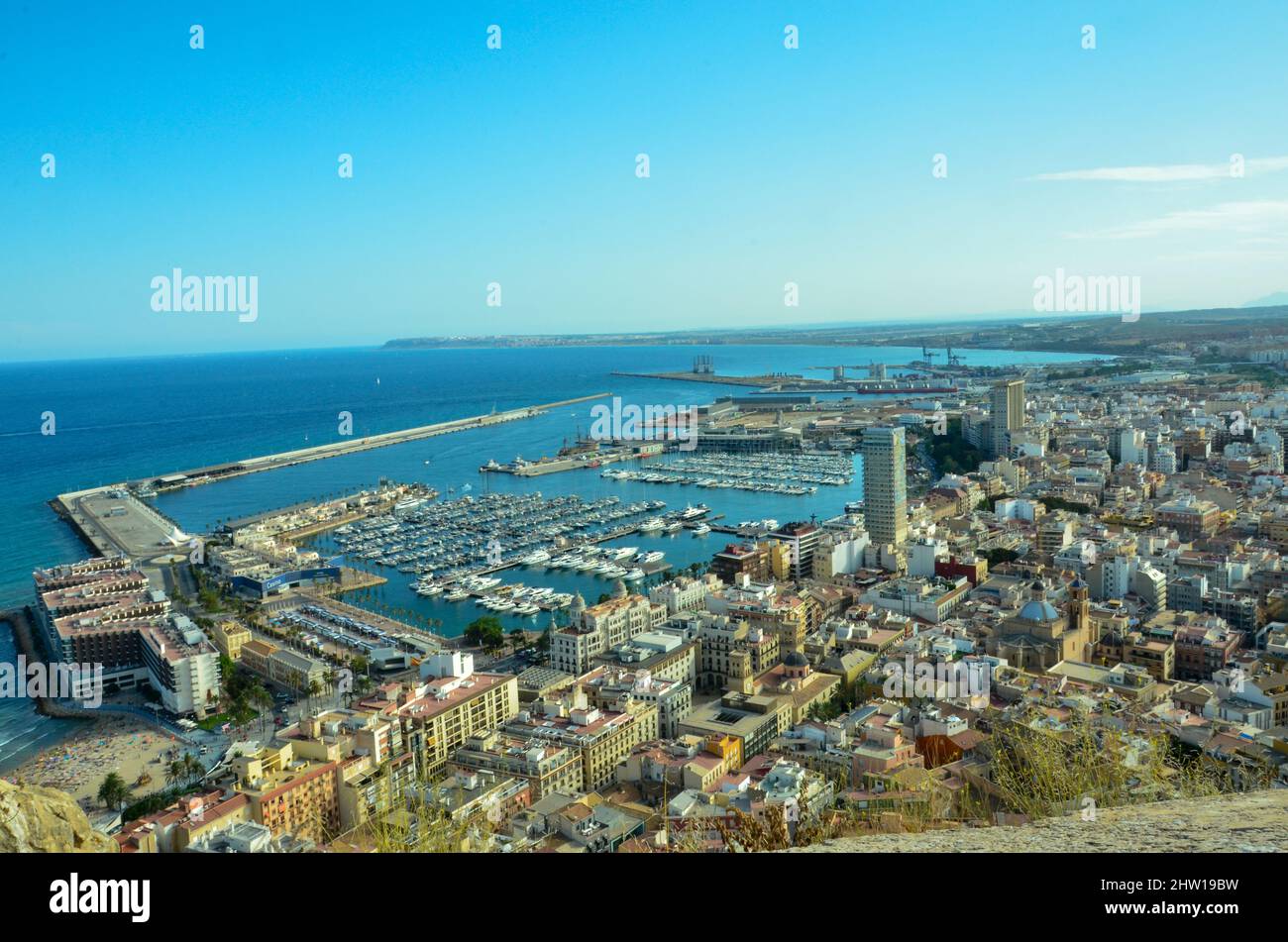 Vista desde el Castillo de Santa Bárbara hasta el puerto de Alicante y el Mar Mediterráneo con muchos veleros y barcos en la bahía Foto de stock