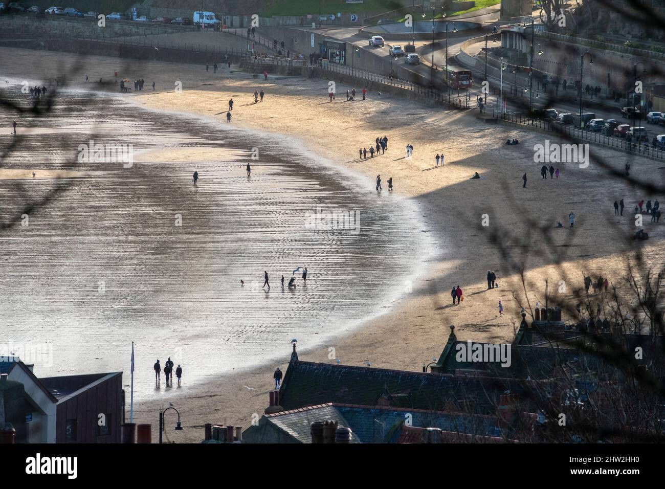 Gente caminando en la playa bajo el sol, en Scarborough, North Yorkshire, Inglaterra Foto de stock