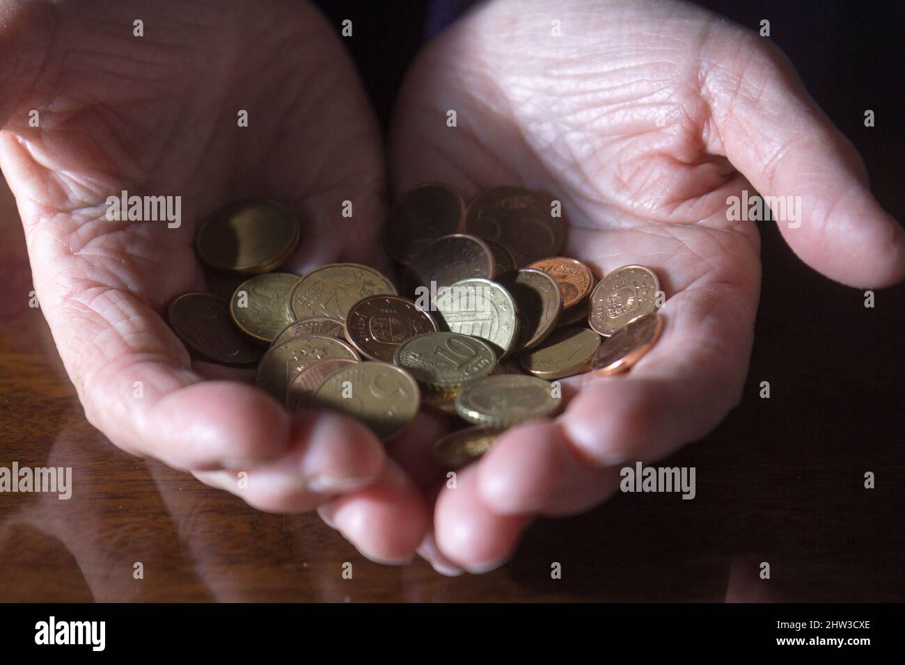 Manos arrugadas de ancianas contando monedas Foto de stock