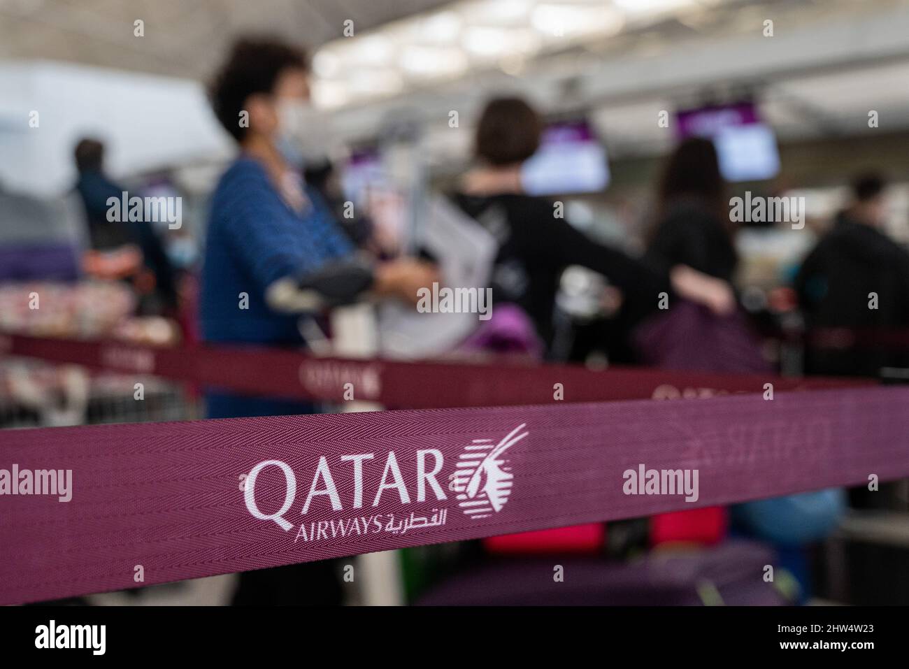 Los pasajeros de vuelos de la compañía estatal de vuelos de Qatar, Qatar  Airway, se ven en fila en un mostrador de facturación en el aeropuerto  internacional de Hong Kong, ya que