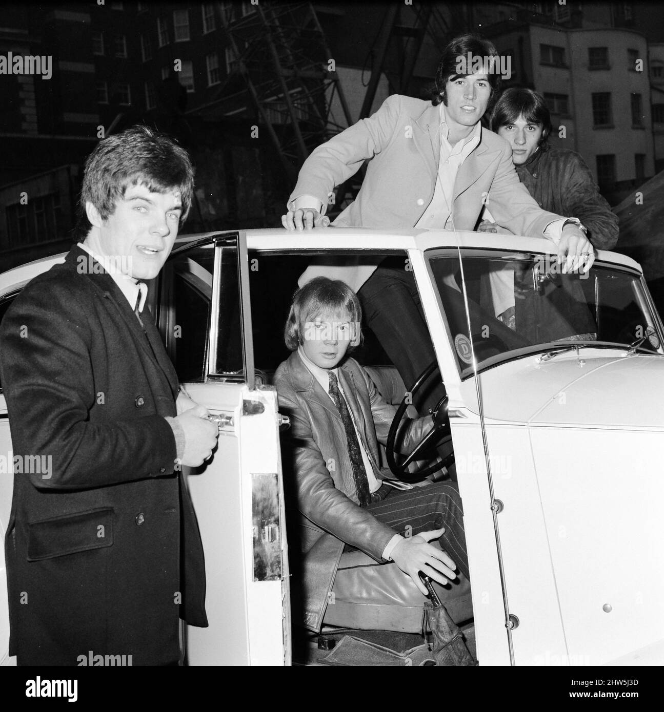 Los Bee Gees examinan un regalo de Navidad temprano del agente Robert Stigwood, un 1948 Rolls Royce Silver Wraith, 12th de diciembre de 1967. El coche fue dado como un regalo especial para marcar y celebrar alcanzar 1 millones de ventas récord de su único Massachusetts. Cuatro de los cinco miembros del grupo miran el coche y lo dan un pulido y limpio. El Sr. Stigwood tenía el coche completamente retapizado y pintado y el motor fue revisado. En la foto: Colin Peterson, Vince Melouney, Barry Gibb y Robin Gibb en Adams Row, Mayfair (Robin Gibb no estaba disponible para la foto) Foto de stock